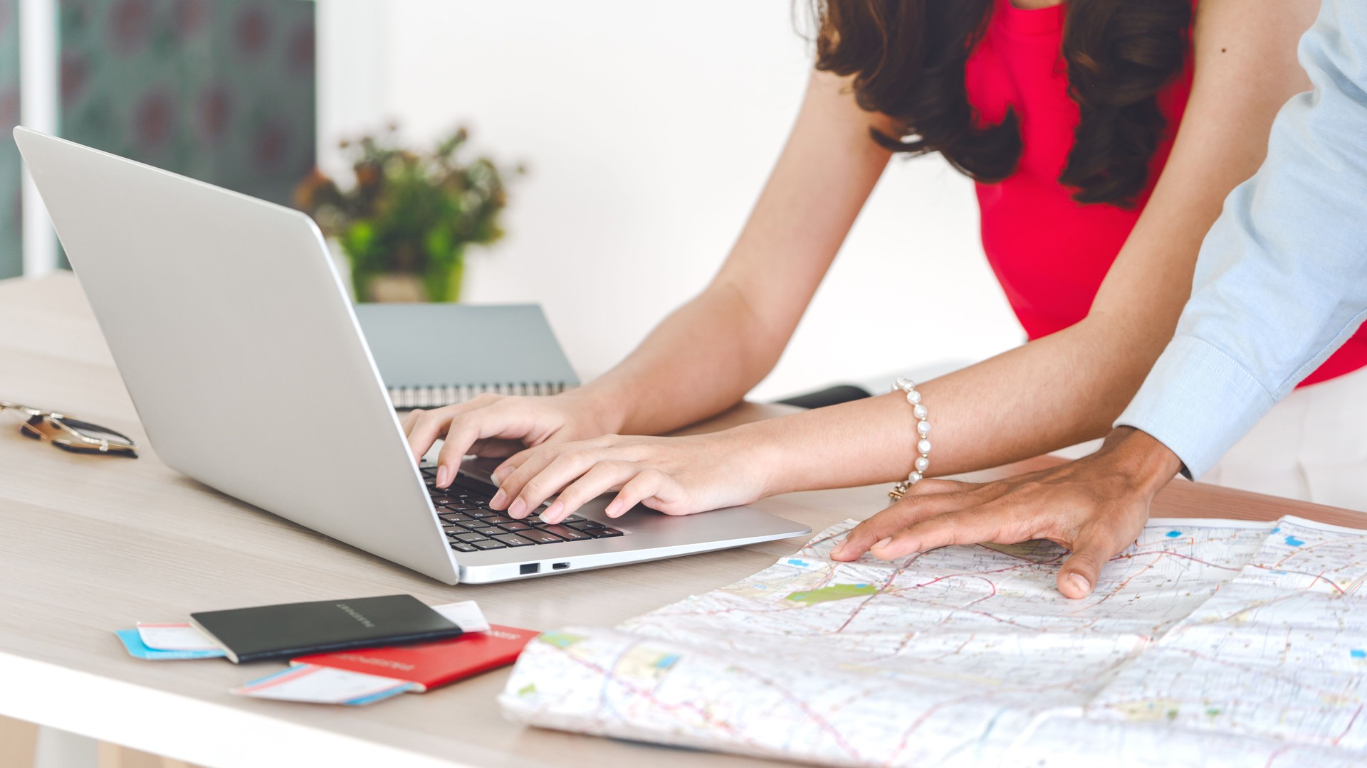 Focus on hand typing keyboard couple man and woman using laptop search place for travel map